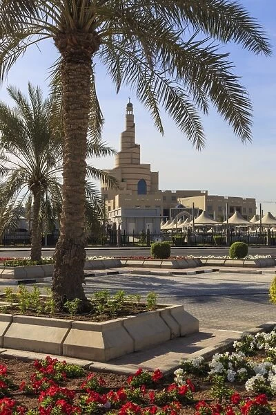 Palm trees and flower beds along Al-Corniche, waterfront promenade, with Qatar Islamic
