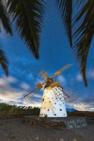 Palm trees framing a lone windmill under Milky Way, El Cotillo, La Oliva, Fuerteventura