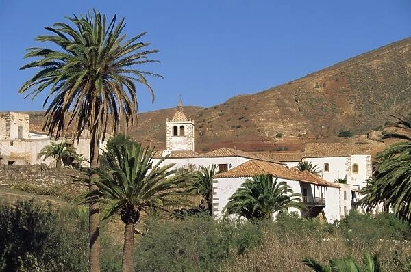 Palm trees, houses and church at Betancuria, on Fuerteventura in the Canary Islands