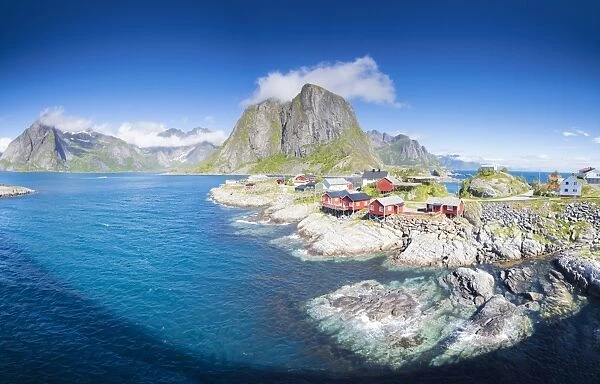 Panorama of the fishing village framed by blue sea and high peaks, Hamnoy, Moskenesoya