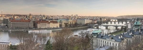 Panorama of the historical bridges and buildings reflected on Vltava River at sunset