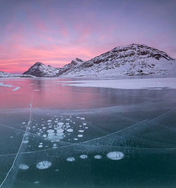 Panorama of ice bubbles and frozen surface of Lago Bianco at dawn, Bernina Pass