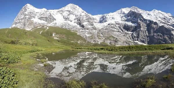 Panorama of snowy peaks reflected in the alpine lake, Wengernalp, Wengen, Bernese Oberland