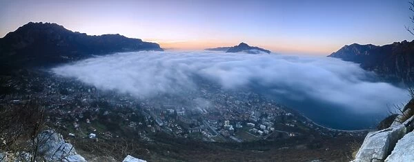 Panoramic of fog at sunrise above the city of Lecco seen from Monte San Martino, Province of Lecco