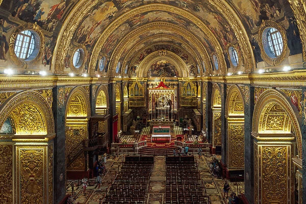 Panoramic interior view of Roman Catholic St. John Co-Cathedral with golden Maltese cross symbols on arches, Valletta, Malta, Europe