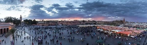 Panoramic view over the Djemaa el Fna at sunset showing Koutoubia Minaret, food stalls