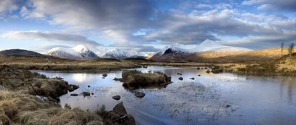 Panoramic view across Lochain Na h Achlaise on clear winter morning towards the snow-covered mountains of the Black Mount range, Rannoch Moor, near Fort William, Highland, Scotland, United