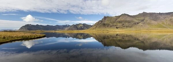 Panoramic view of mountains and blue sky reflecting in lake, near Vik, South Iceland