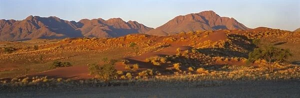 Panoramic view of mountains and dune glowing in last