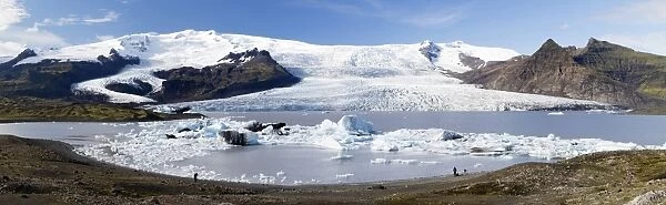 Panoramic view of tongue of the Vatnajokull Glacier creeping between mountains towards