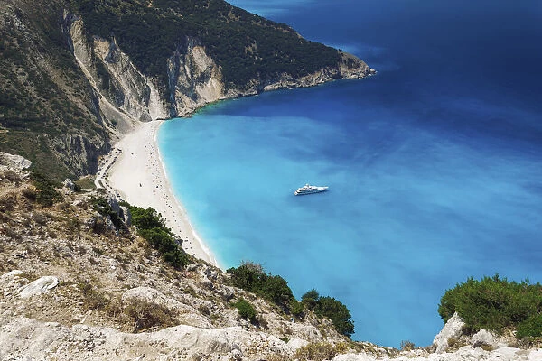 Panoramic view of world famous Myrtos beach with crystal clear waters and moored yacht in Kefalonia island, Greek Islands, Greece, Europe