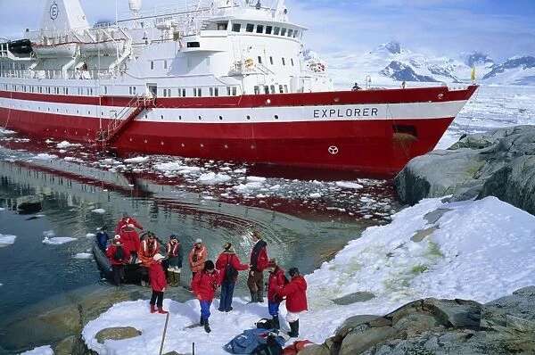 Passengers take small boat to the Explorer cruise ship anchored close inshore