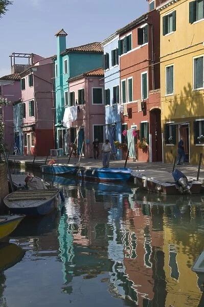 Pastel coloured houses reflected in a canal, Burano, Venetian Lagoon, Venice