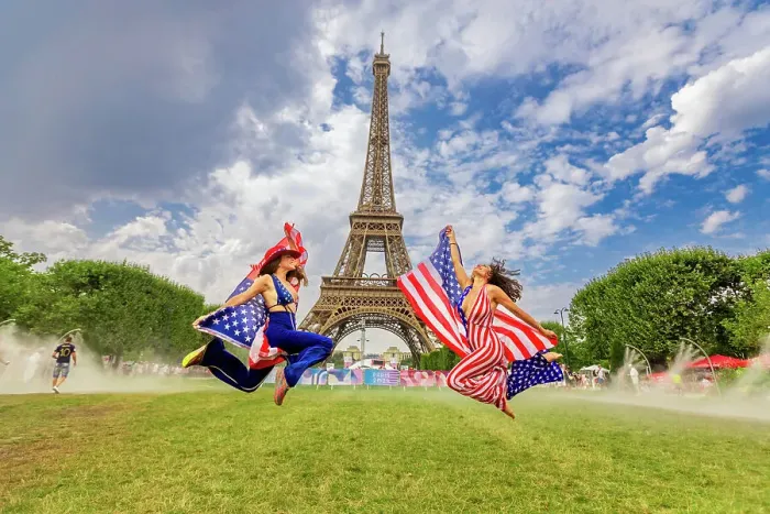 Framed Print : Patriotic American Woman jumping and cheering for Team USA and the Paris 2024 Olympics in front of the Eiffel Tower beach volleyball stadium, Paris, France, Europe