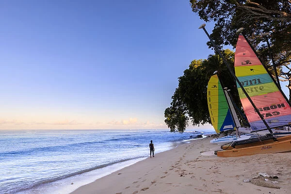 Paynes Bay at sunrise, lady exercises on beach, colourful sail boats