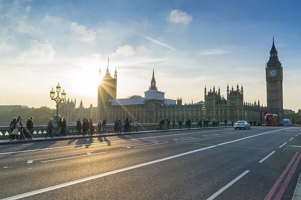 Pedestrians on Westminster Bridge with Houses of Parliament and Big Ben at sunset