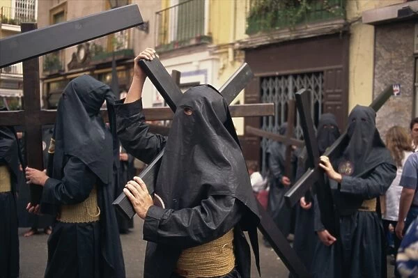 Penitents bearing crosses in procession, Holy Week (Semana Santa), Seville