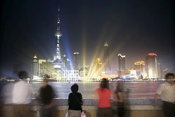 People on the Bund looking at the Oriental Pearl Tower in Pudong District