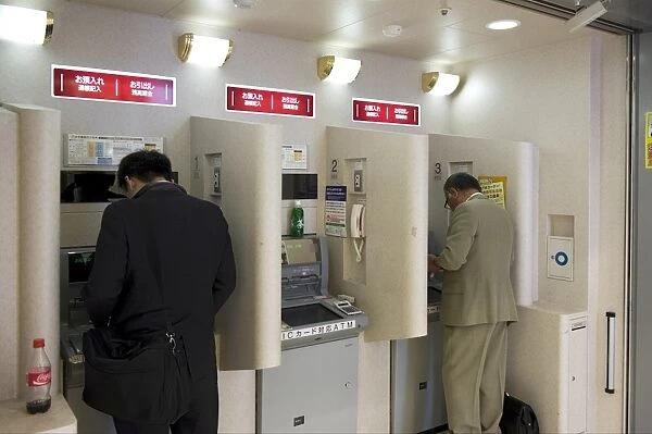 People doing after-hours banking at bank teller machines in Japan, Asia