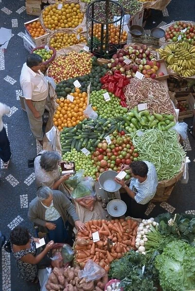 People at a fruit and vegetable stall in the market hall in Funchal