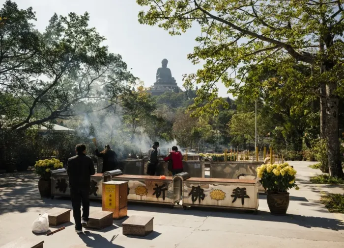 Framed Print : People lighting incense at Po Lin Monastery with Big Buddha statue in background Framed Print : People lighting incense at Po Lin Monastery with Big Buddha statue in background