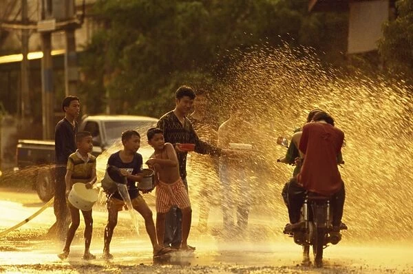 People on a motorbike being showered with water by