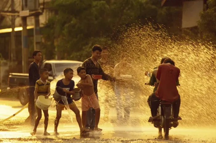 Framed Print : People on a motorbike being showered with water by Framed Print : People on a motorbike being showered with water by