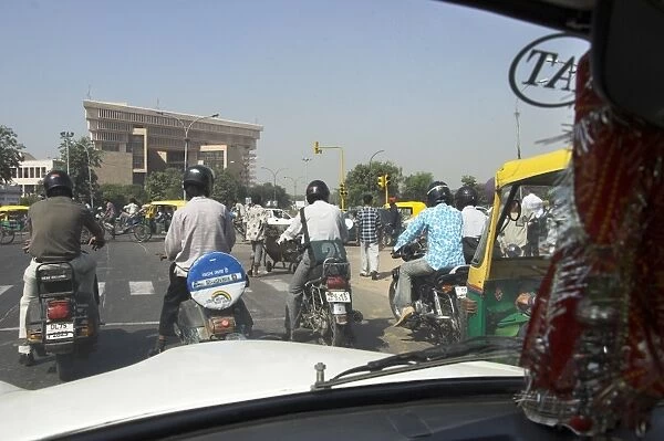 People on motorcycles waiting at traffic lights