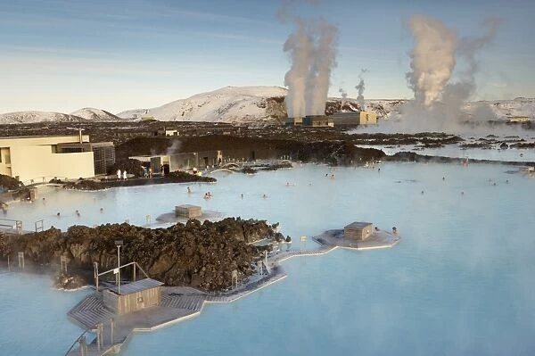 People relaxing in Blue Lagoon geothermal spa, Svartsengi Geothermal Power Station in the distance