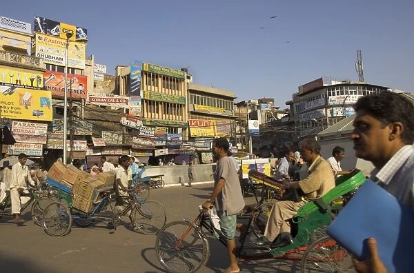 People and rickshaws crossing the square