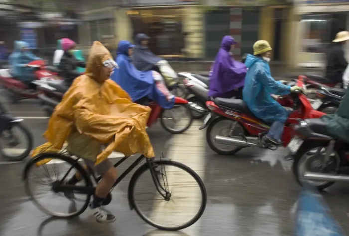 Framed Print : People riding bikes and mopeds in the rain wearing nylon protection Framed Print : People riding bikes and mopeds in the rain wearing nylon protection