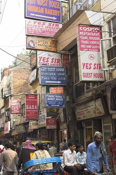 People riding rickshaws and street signs
