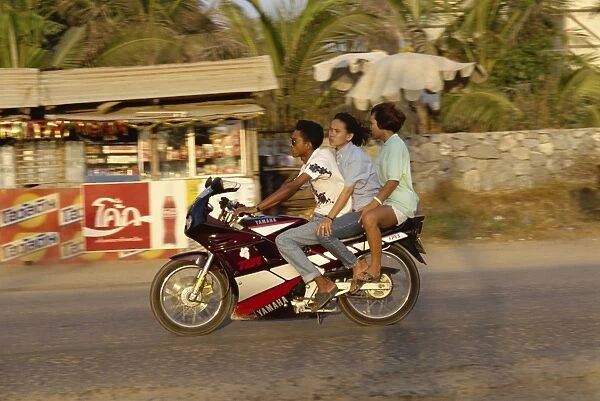 Three people riding a Yamaha motorbike at Jomtien Beach