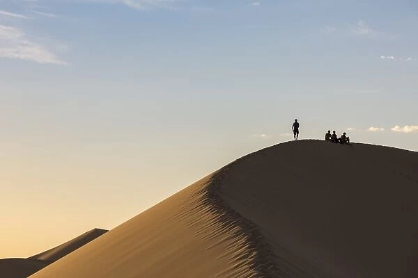 People in silhouette on Khongor sand dunes in Gobi Gurvan Saikhan National Park, Sevrei district