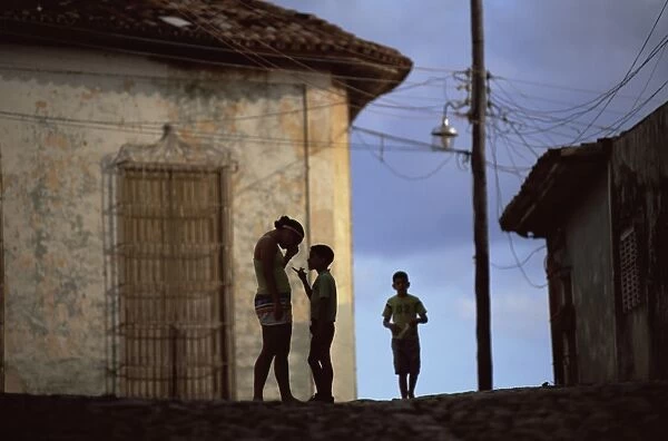 People in silhouette on a street in Trinidad, Cuba, West Indies, Central America