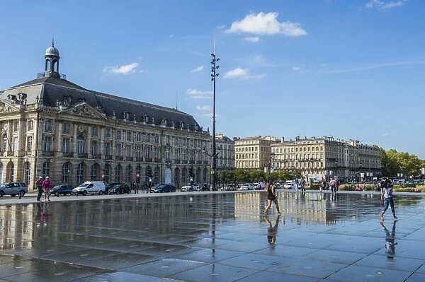 People standing in the water mirror on Place de la Bourse, Bordeaux, Aquiaine, France