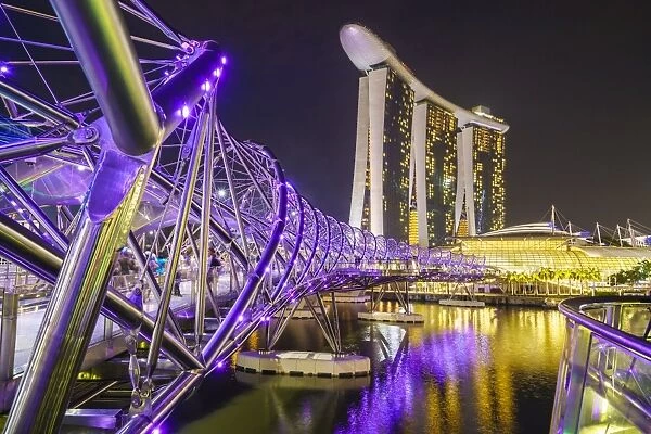 People strolling on the Helix Bridge towards the Marina Bay Sands and ArtScience Museum at night