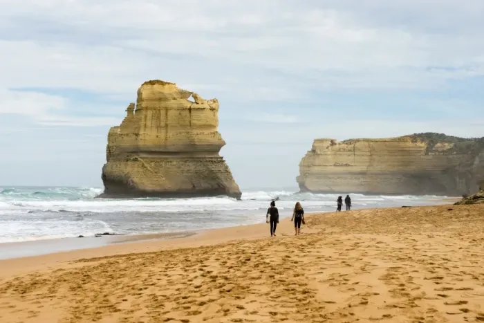 Framed Print : People walk along a beach with one of the Twelve Apostles geological formation in the background Framed Print : People walk along a beach with one of the Twelve Apostles geological formation in the background