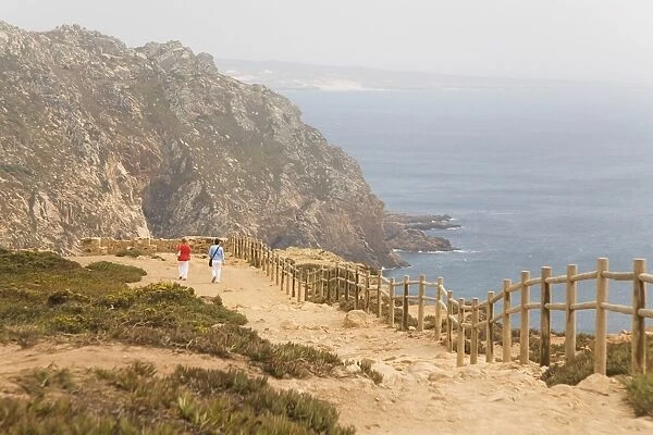 People walk along cliffs overlooking the Atlantic Ocean at Europes most westerly point at Cabo da Roca