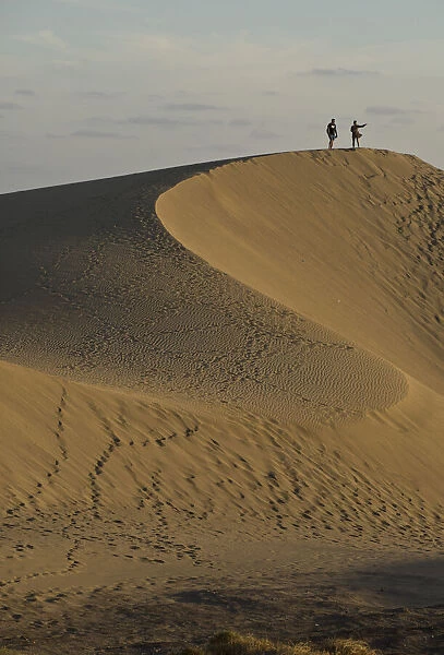 People watching the sunset and taking selfie photos at Maspalomas sand dunes, near Playa de los Ingleses, Gran Canaria, Canary Islands, Spain, Atlantic, Europe