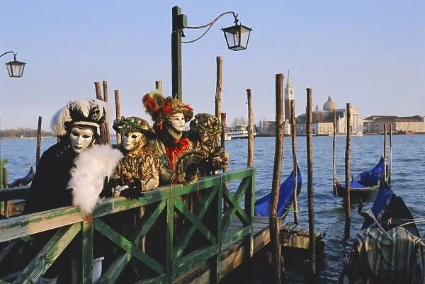 People wearing masked carnival costumes