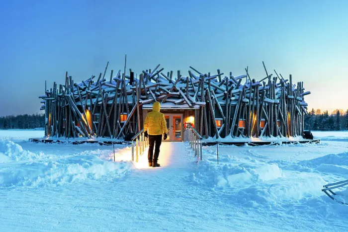 Framed Print : Person stands on the bridge connecting the main building of the illuminated Arctic Bath hotel made of logs, dusk time, Harads, Swedish Lapland, Norrbotten, Sweden, Scandinavia, Europe