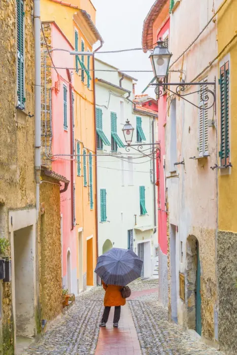Framed Print : A person with an umbrella in the main street of Civezza, Province of Imperia, Liguria Framed Print : A person with an umbrella in the main street of Civezza, Province of Imperia, Liguria