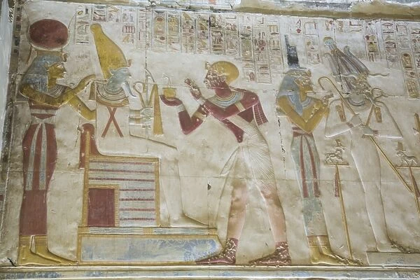 Pharaoh Seti I in center making an offering to the seated God Osiris, Temple of Seti I