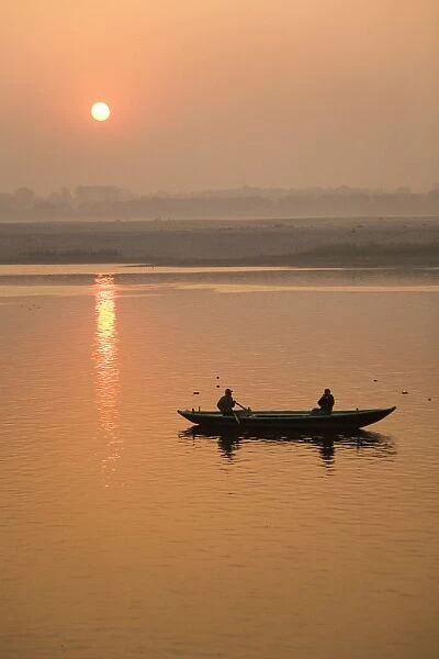 A photographer takes a photo from a rowing boat on the Ganga (Ganges) River at Varanasi