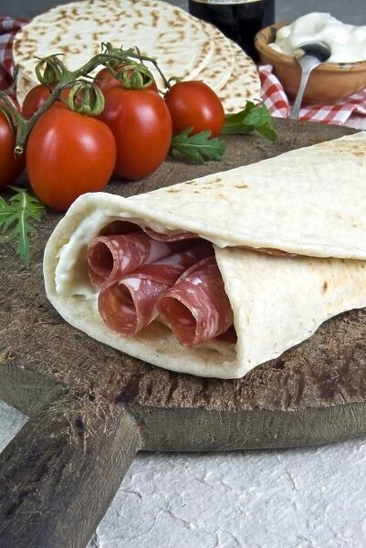 Piadina flat bread with salami and stracchino cheese, typical Emilia Romagna food