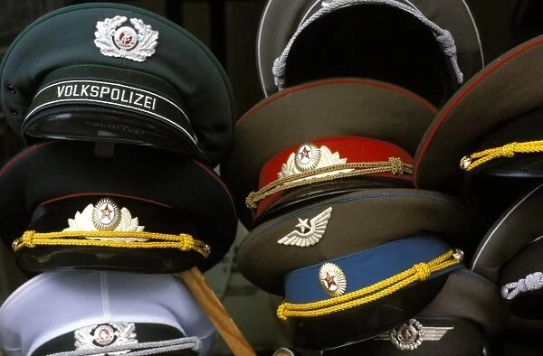 A pile of Communist era army and police hats for sale as souvenirs