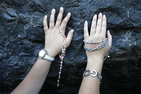 Pilgrims touching the Lourdes grotto, Lourdes, Hautes Pyrenees, France, Europe