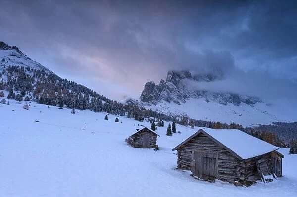 Pink clouds at dawn on the Odle and hut covered with snow, Malga Caseril, Funes Valley