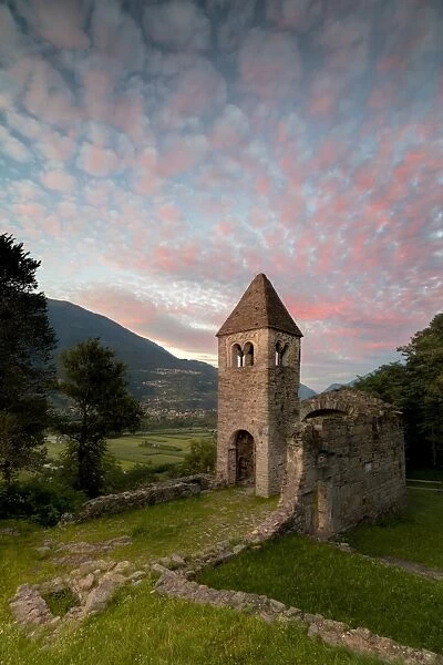 Pink clouds at sunset on the old Abbey of San Pietro in Vallate, Piagno, Sondrio province